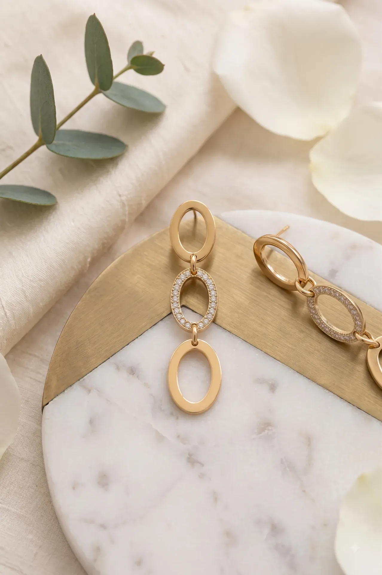 Tiered gold-finish oval links with crystal accents.